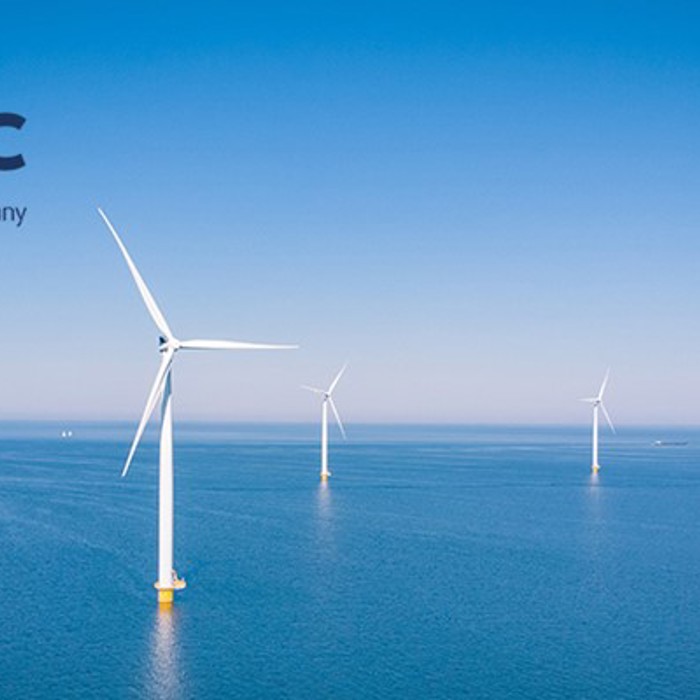 Turbinas eólicas offshore no oceano sob um céu azul claro, com os logótipos das empresas SMC e OEG Offshore no canto superior esquerdo.