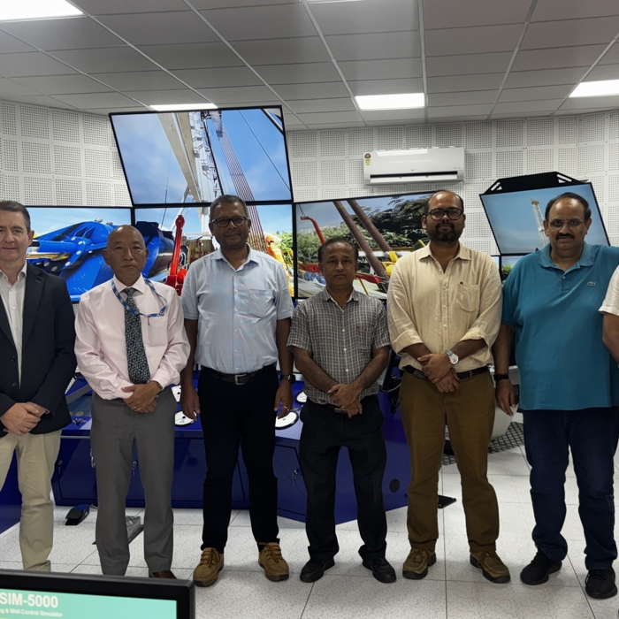 huit hommes debout devant de grands écrans de simulateurs